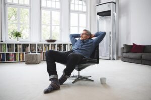 Man sitzt in Sessel mit verschränkten Armen. Im Hintergrund sieht man den myHomelift 2